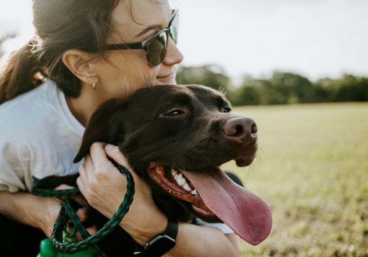 Apartments at Palladian Place in Durham, NC, a pet friendly community with a girl hugging her happy dog