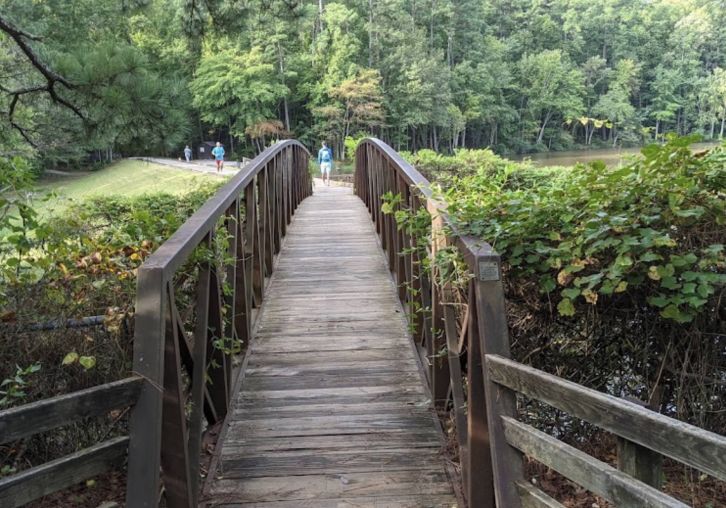 Apartments at Palladian Place in Durham, NC with nearby parks and walking paths with a footbridge and joggers